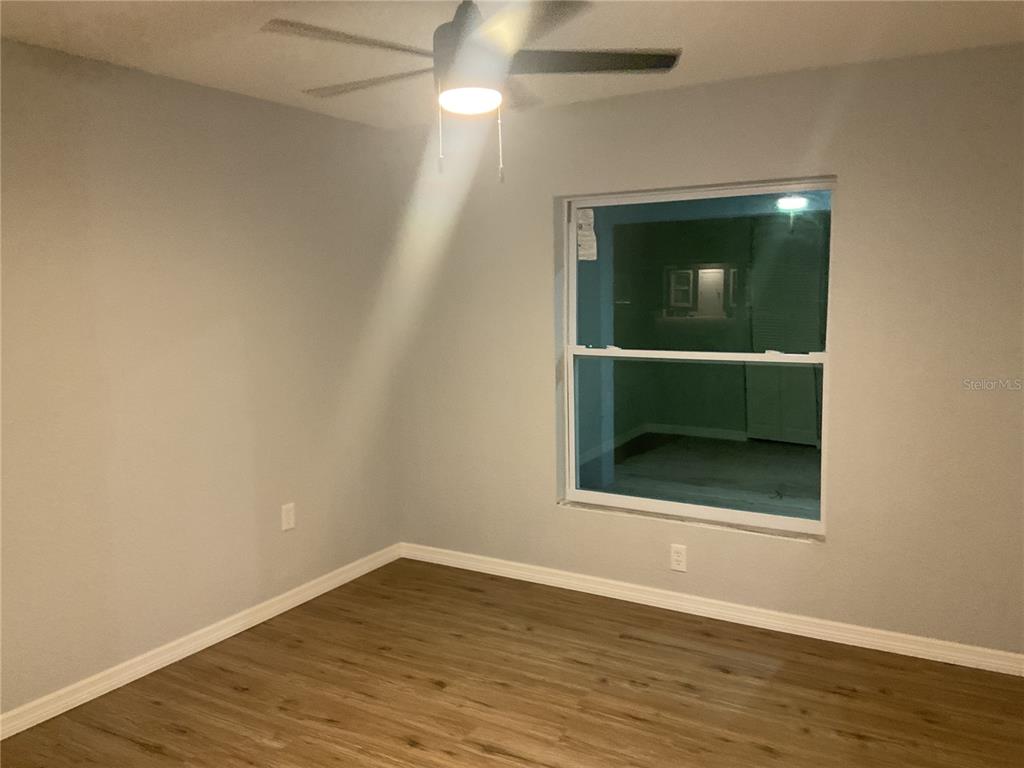 2432 Northwest 5th Street Okeechobee, FL 34972 - Photo 16 of 24 an empty room with wooden floor and windows