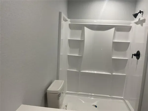a bathroom with a granite countertop sink toilet and a mirror
