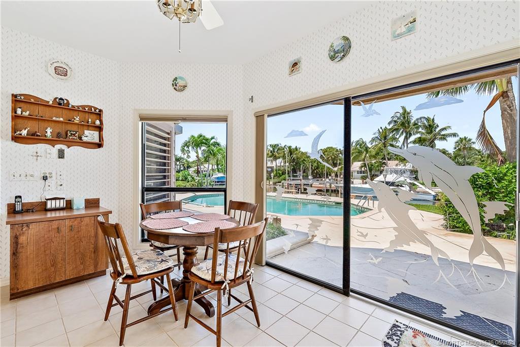 19 Island Road Sewall's Point, FL 34996 - Photo 25 of 50 a view of a dining room with furniture large windows and a chandelier