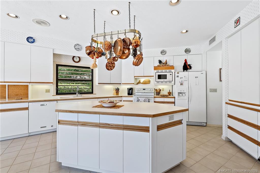 19 Island Road Sewall's Point, FL 34996 - Photo 27 of 50 a kitchen with cabinets a sink and white stainless steel appliances