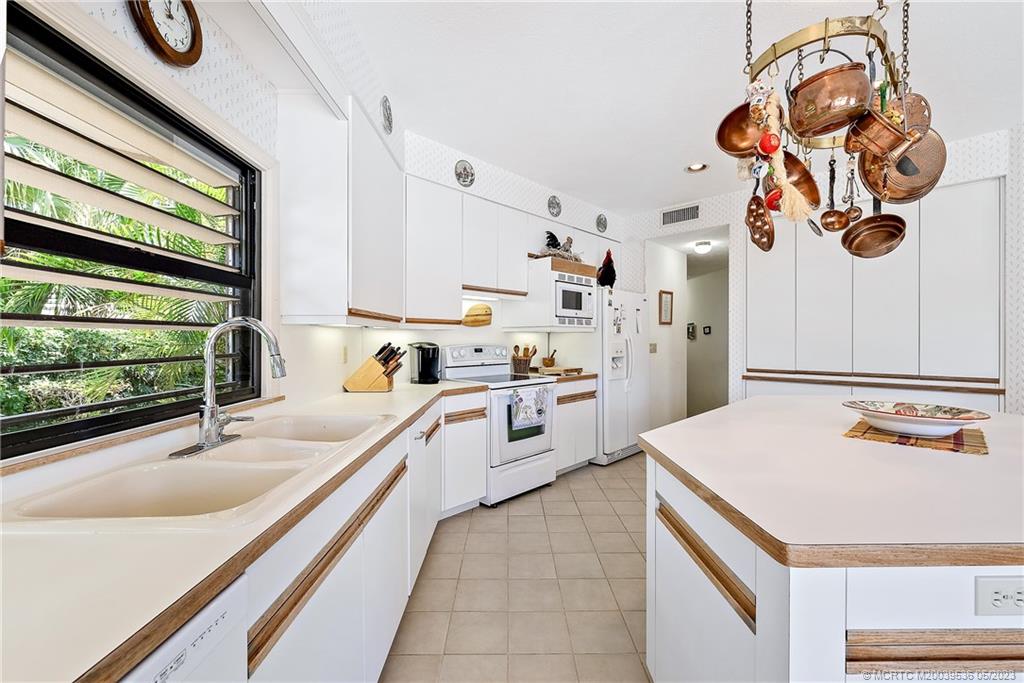 19 Island Road Sewall's Point, FL 34996 - Photo 28 of 50 a kitchen with a sink dishwasher and a stove with a dining table