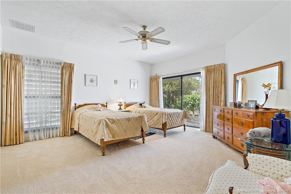 19 Island Road Sewall's Point, FL 34996 - Photo 33 of 50 a spacious bedroom with a bed and glass walk in closet