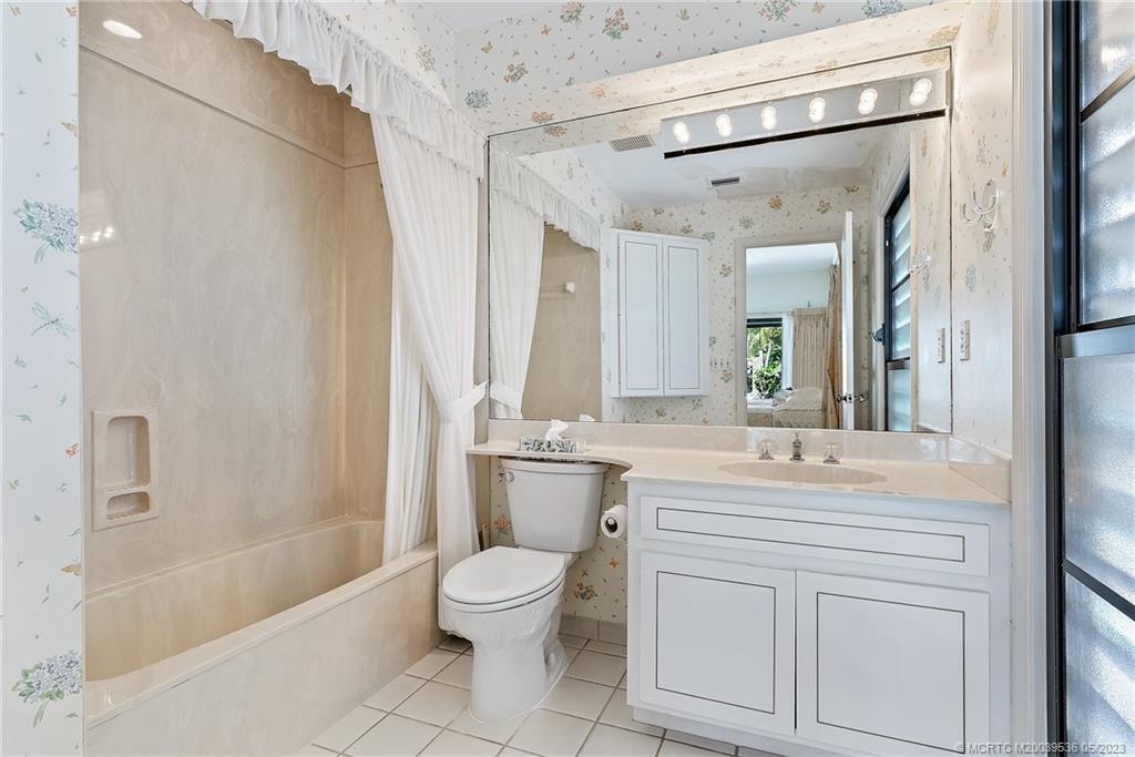 19 Island Road Sewall's Point, FL 34996 - Photo 35 of 50 a bathroom with a double vanity sink a toilet a mirror and shower