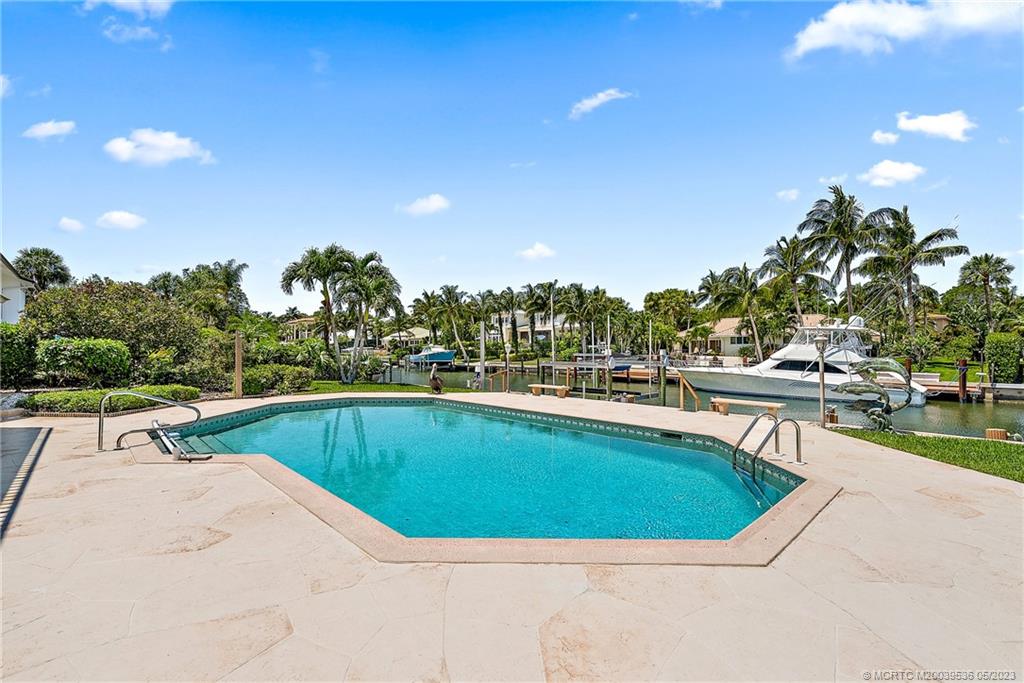 19 Island Road Sewall's Point, FL 34996 - Photo 45 of 50 a view of swimming pool that has lawn chairs with plants and trees