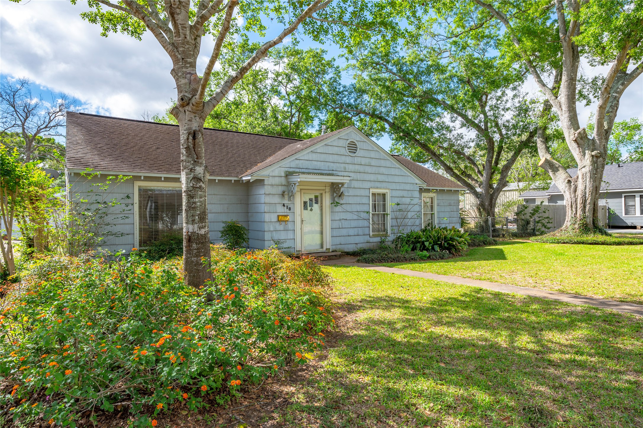 418 East Strand Street El Campo, TX 77437 - Photo 1 of 20 a front view of a house with a garden and tree
