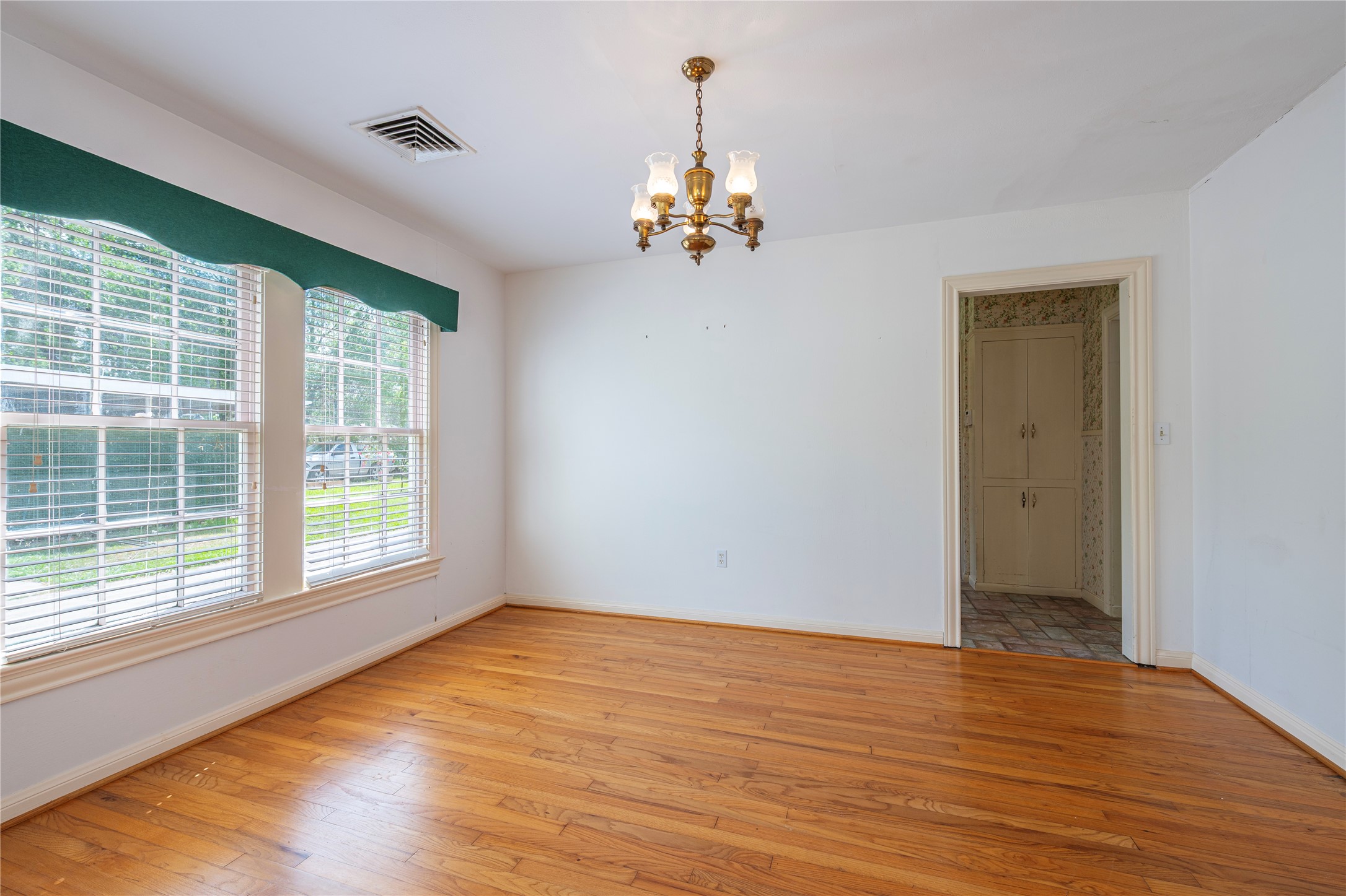 418 East Strand Street El Campo, TX 77437 - Photo 12 of 20 a view of an empty room with wooden floor and a window