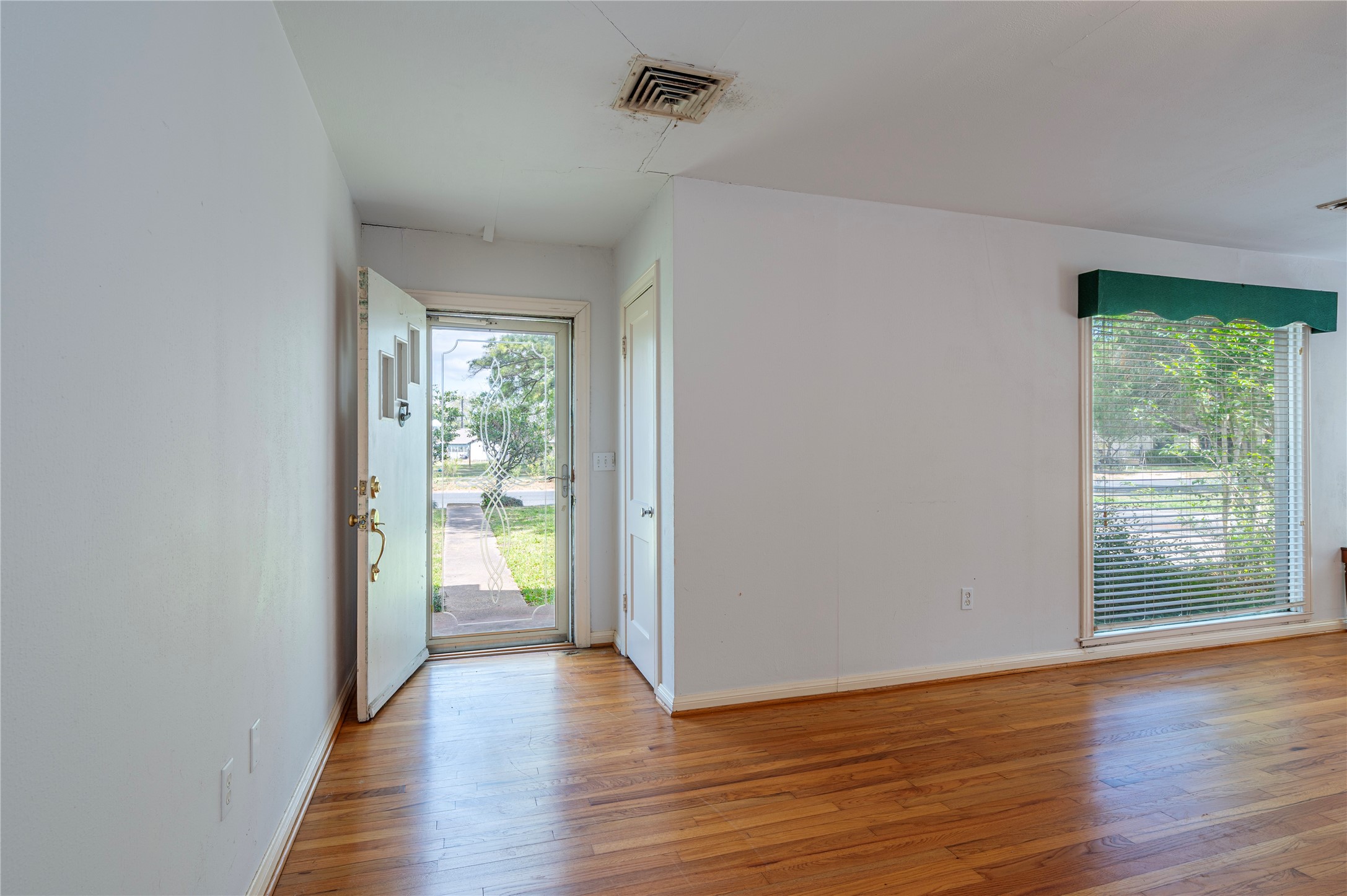 418 East Strand Street El Campo, TX 77437 - Photo 8 of 20 a view of an empty room with wooden floor and a window