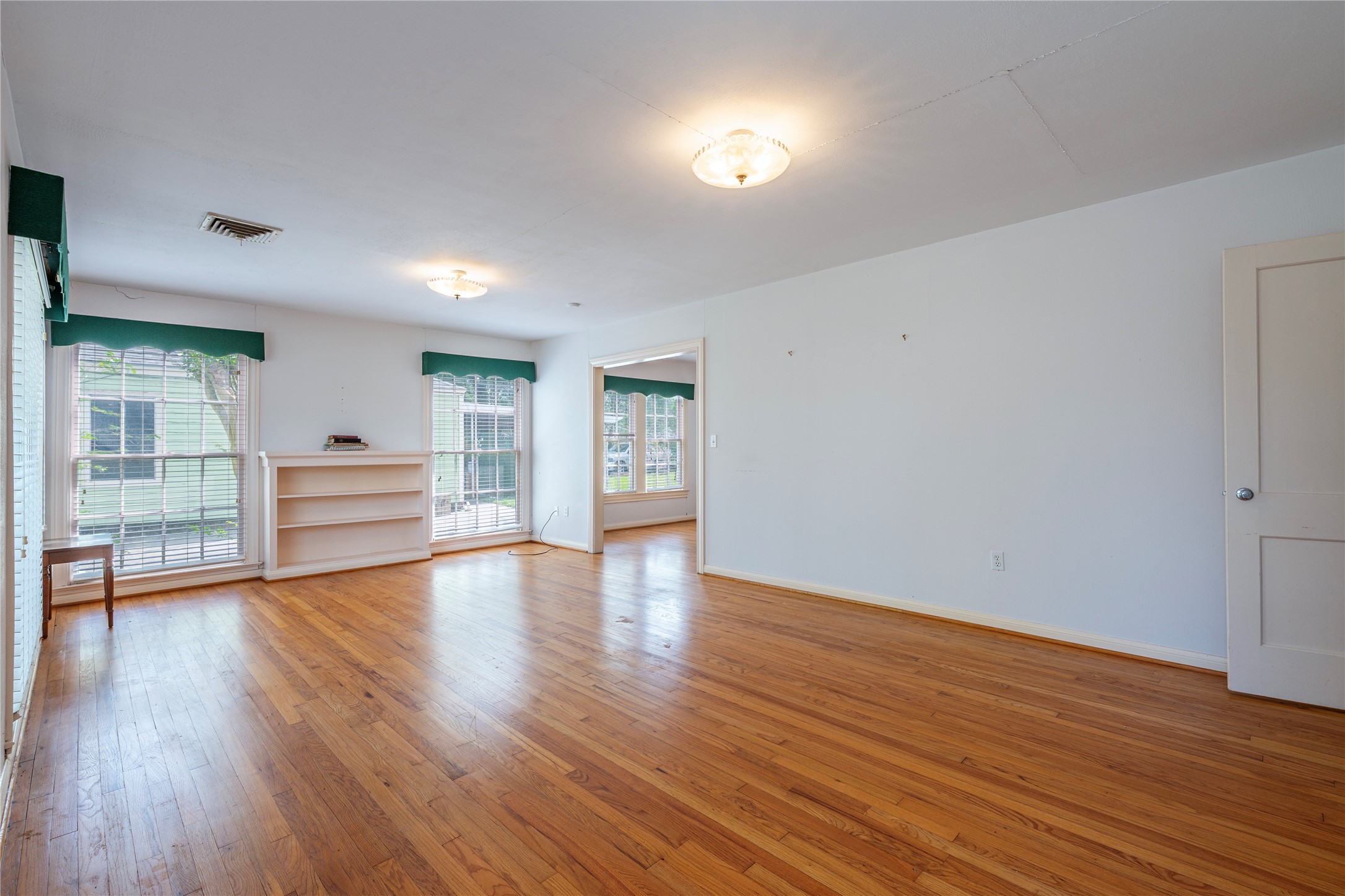 418 East Strand Street El Campo, TX 77437 - Photo 9 of 20 a view of an empty room with wooden floor and a window