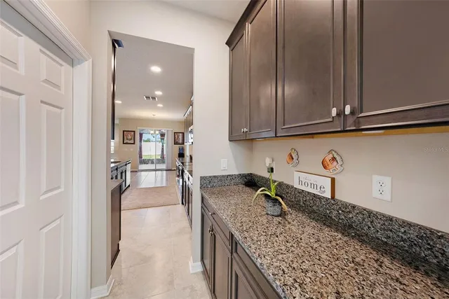 a kitchen with granite countertop a sink a stove and cabinets