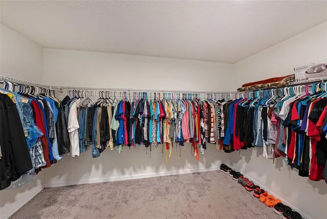 a view of walk in closet with clothes