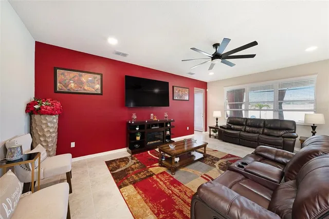 a living room with furniture a flat screen tv and a window
