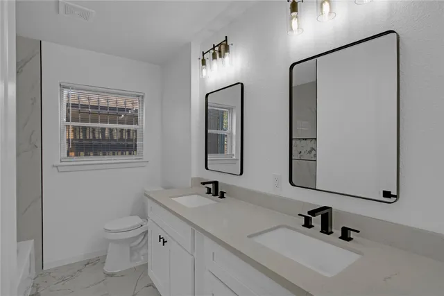 a bathroom with 2 sink and a mirror