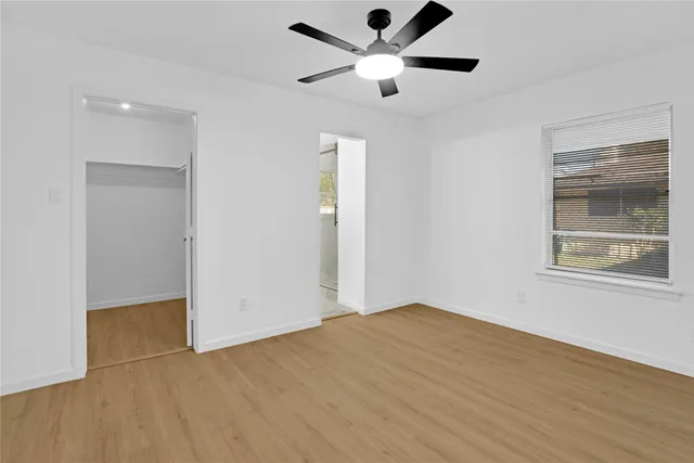 an empty room with fan and windows