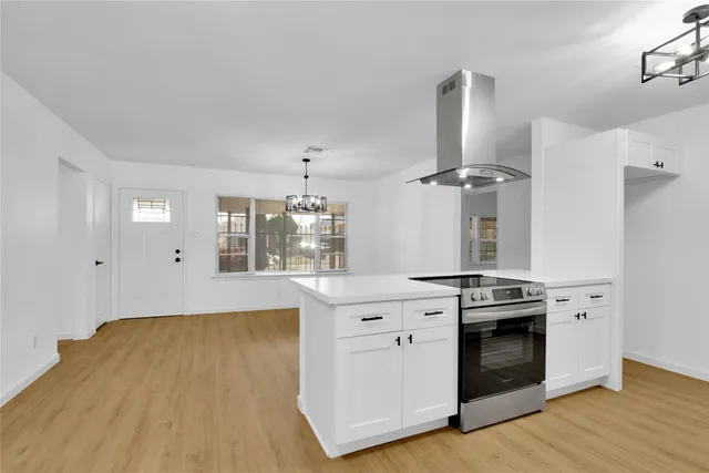 a kitchen with granite countertop a stove and a wooden floors