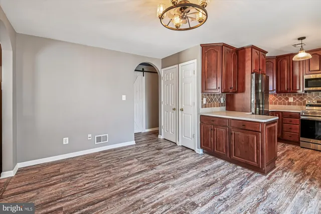 a view of a livingroom with wooden floor and a ceiling fan