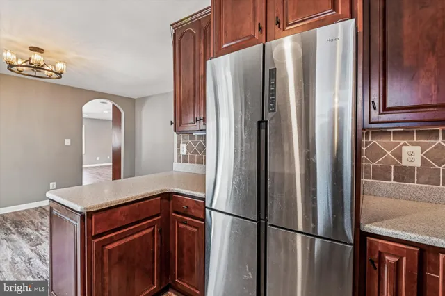 a large kitchen with stainless steel appliances granite countertop a stove a sink dishwasher and a refrigerator with wooden floor