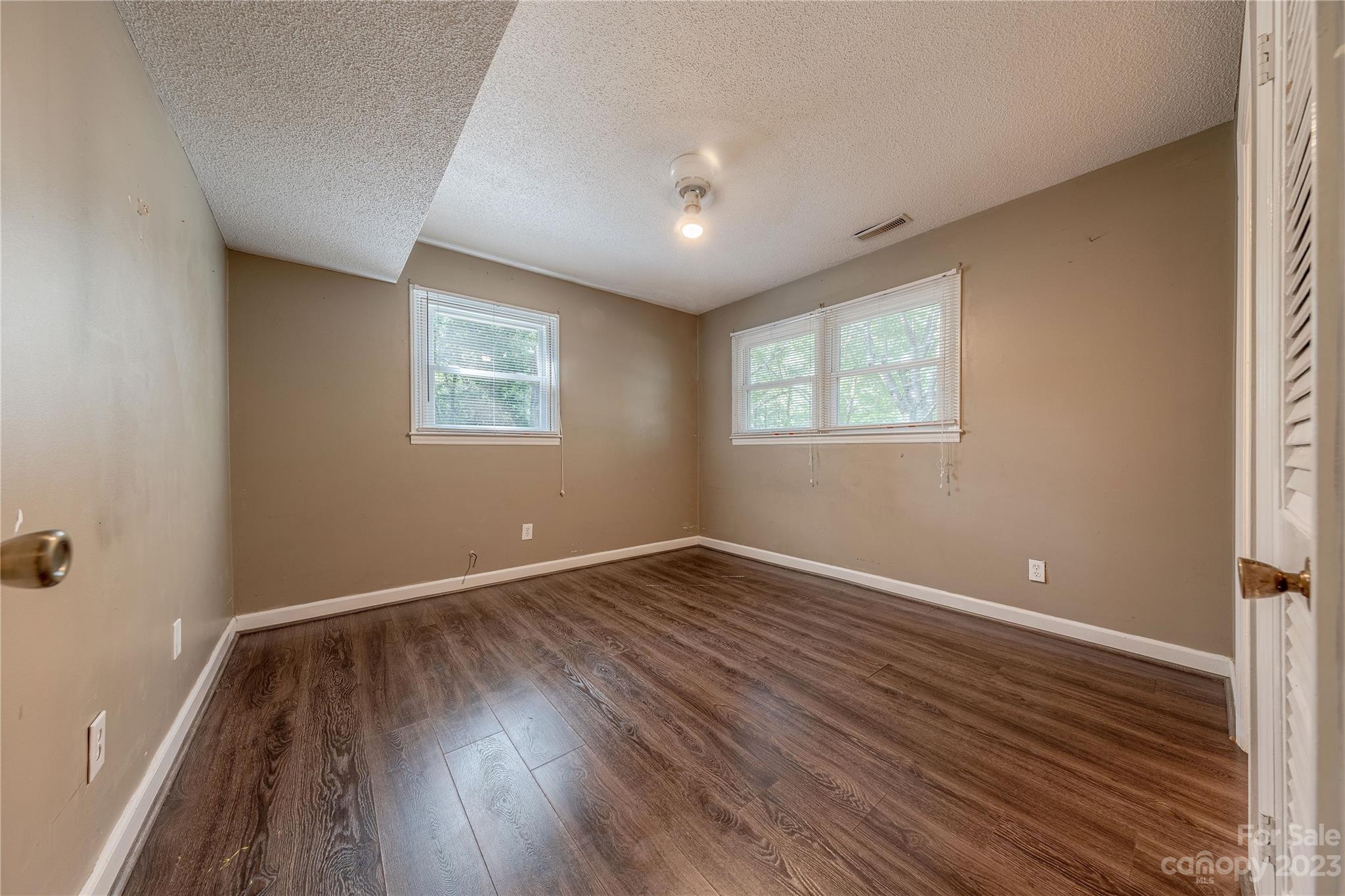 1702 Carson Street Monroe, NC 28110 - Photo 18 of 29 an empty room with wooden floor and windows