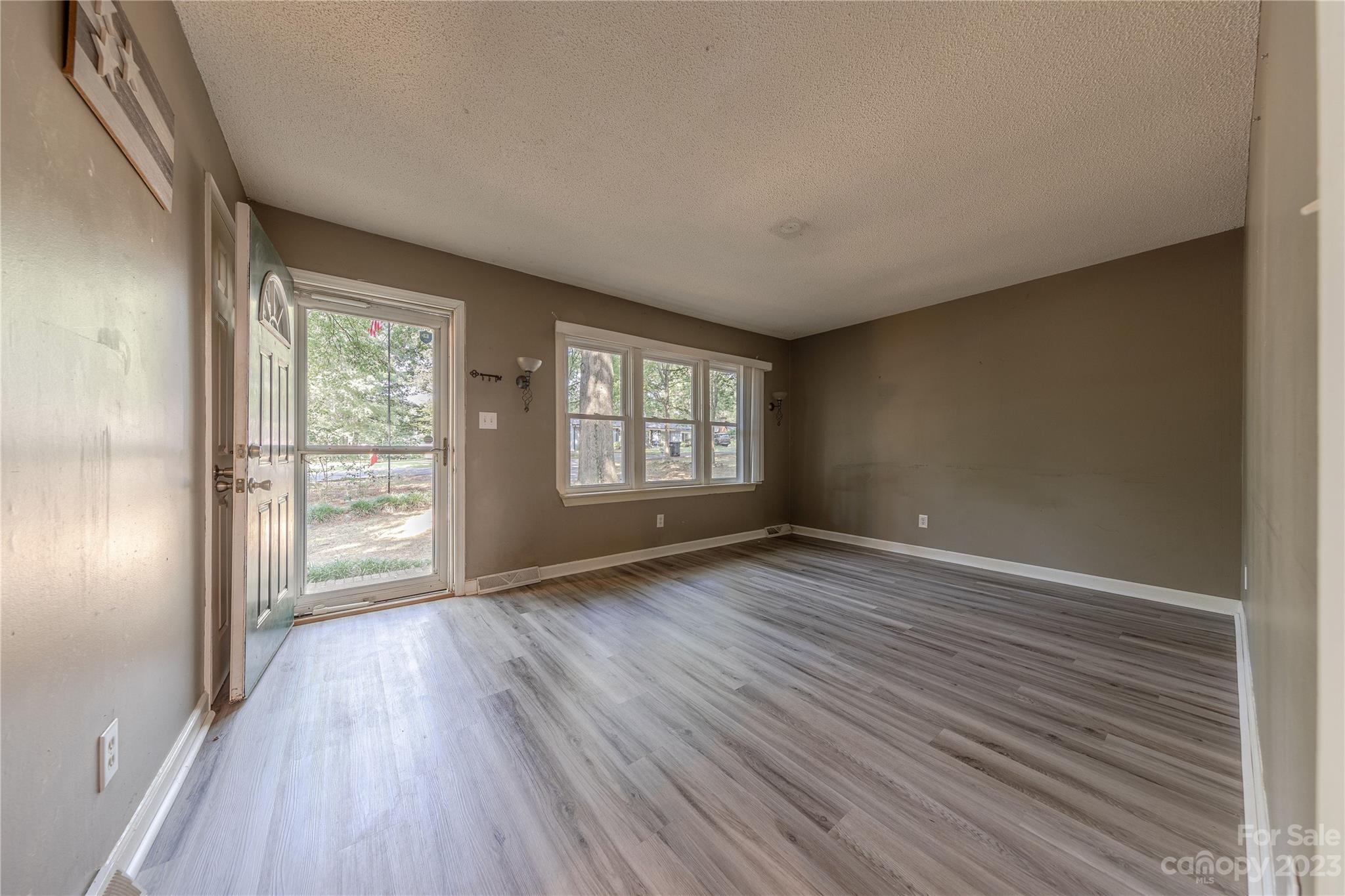 1702 Carson Street Monroe, NC 28110 - Photo 2 of 29 a view of an empty room with wooden floor and a window