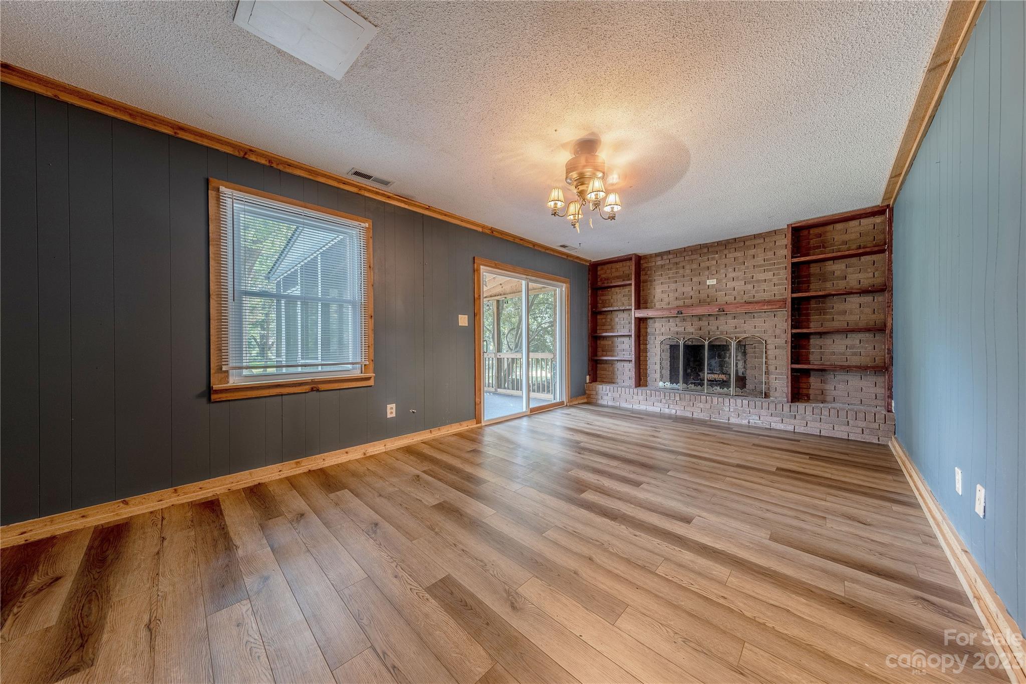 1702 Carson Street Monroe, NC 28110 - Photo 8 of 29 wooden floor fireplace and windows in an empty room