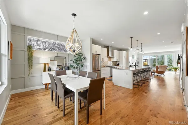 a view of a dining room and livingroom with furniture wooden floor a chandelier