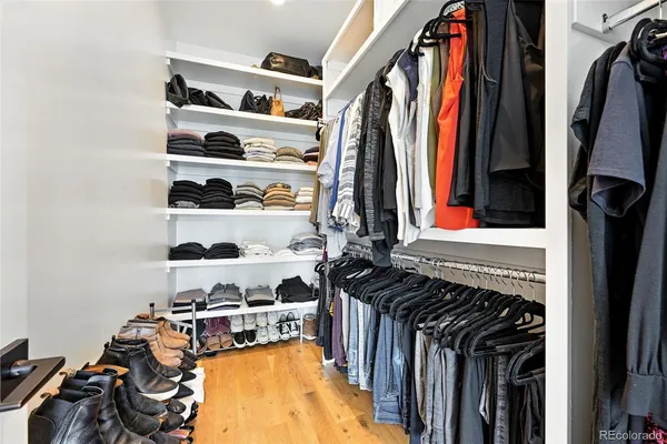 a view of walk in closet with clothes and shoes