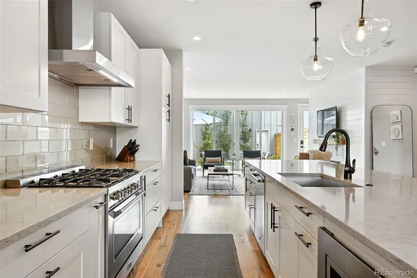a kitchen with stainless steel appliances granite countertop a sink stove and cabinets