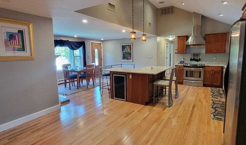 22 Ledgewood Road Wakefield, MA 01880 - Photo 11 of 34 a kitchen with stainless steel appliances granite countertop a stove top oven a sink dishwasher a dining table and chairs with wooden floor