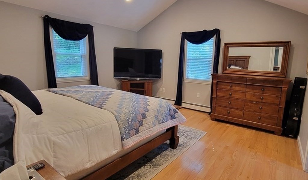 22 Ledgewood Road Wakefield, MA 01880 - Photo 16 of 34 a bedroom with a bed a mirror on dresser and a flat screen tv