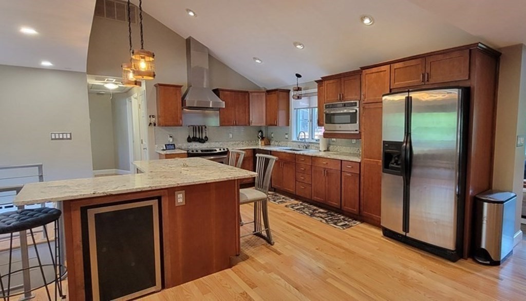 22 Ledgewood Road Wakefield, MA 01880 - Photo 9 of 34 a kitchen with kitchen island granite countertop wooden cabinets and refrigerator
