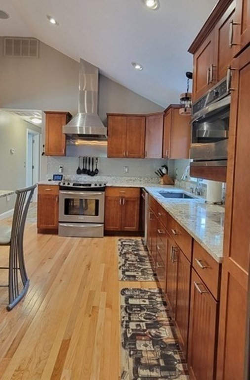 22 Ledgewood Road Wakefield, MA 01880 - Photo 10 of 34 a kitchen with stainless steel appliances granite countertop a stove a sink dishwasher and a refrigerator with wooden cabinets