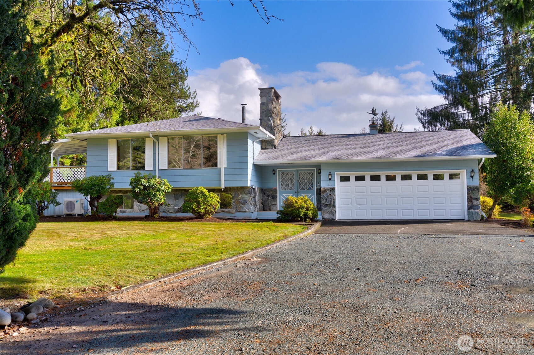 a front view of house with yard and trees in the background