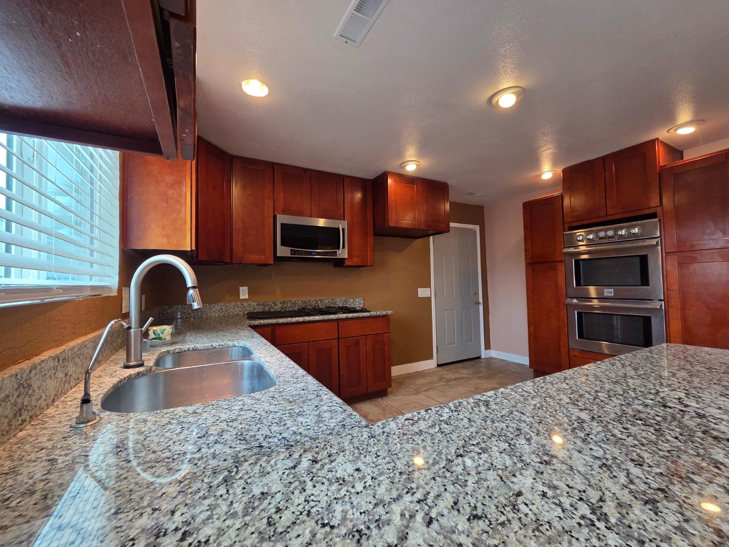 5010 Powerline Road, Unit D Olivehurst, CA 95961 - Photo 4 of 12 a kitchen with stainless steel appliances granite countertop a sink a stove a refrigerator cabinets and a sink
