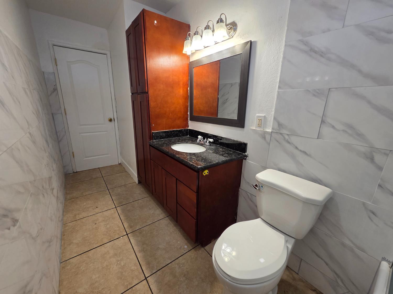 5010 Powerline Road, Unit D Olivehurst, CA 95961 - Photo 7 of 12 a bathroom with a toilet a sink and mirror