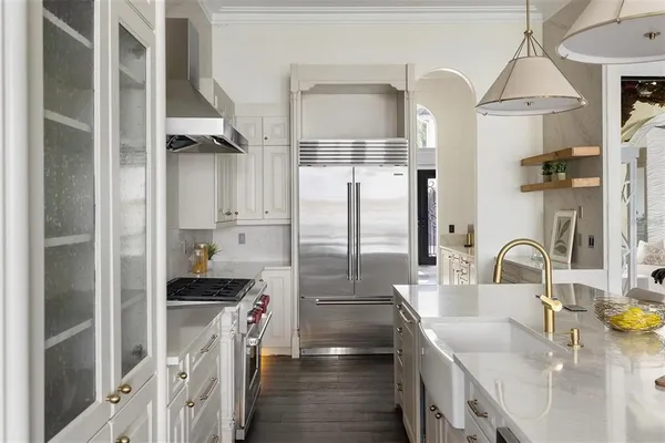 a kitchen with kitchen island a counter top space a sink and stainless steel appliances