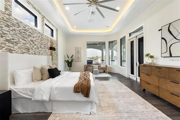 a bedroom with a large bed and ceiling fan