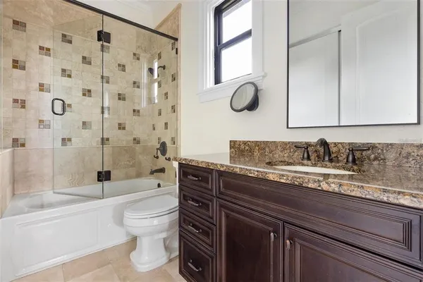 a bathroom with a granite countertop sink a toilet and a bathtub
