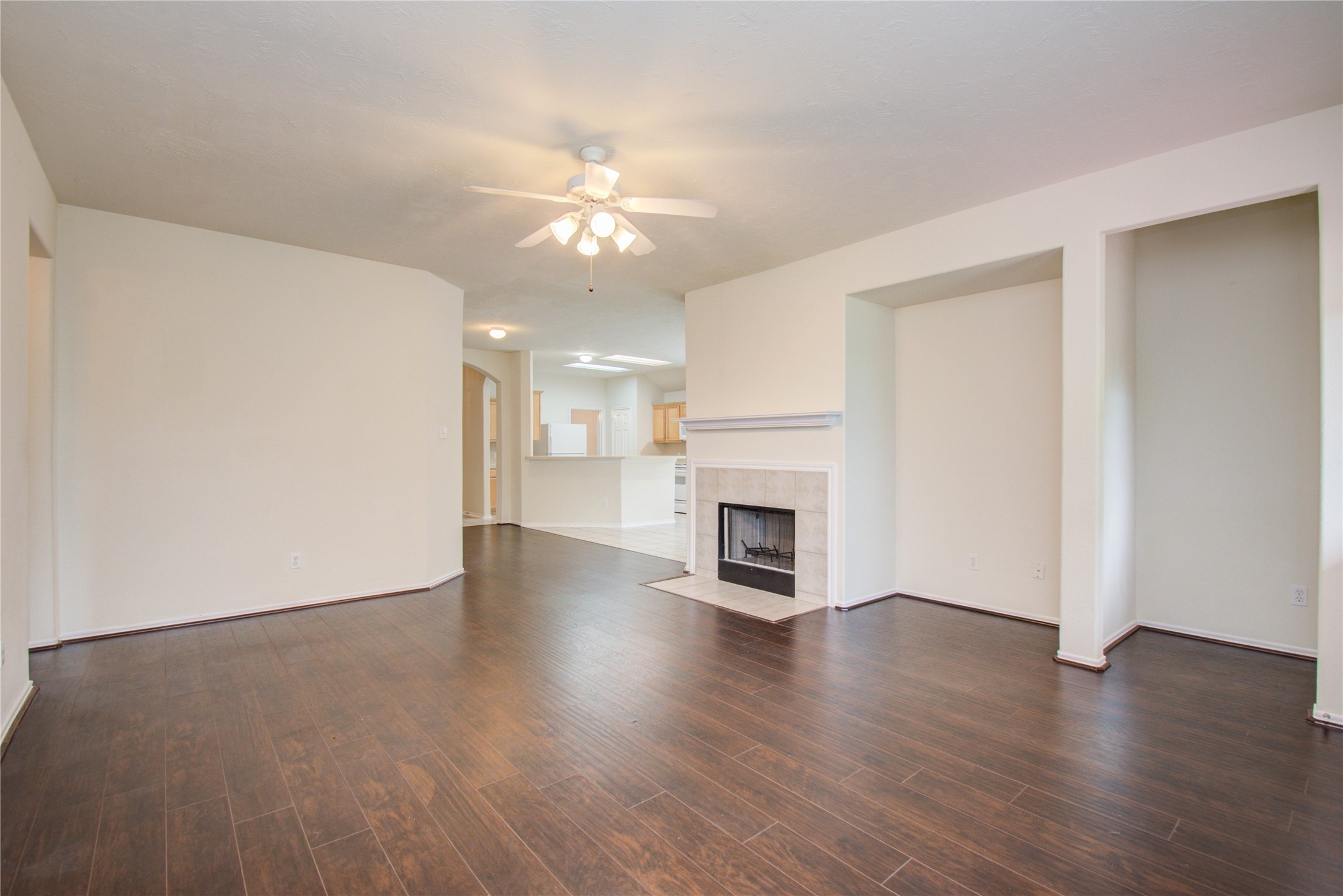 5715 Afton Ridge Lane Houston, TX 77084 - Photo 19 of 37 an empty room with wooden floor fireplace and windows