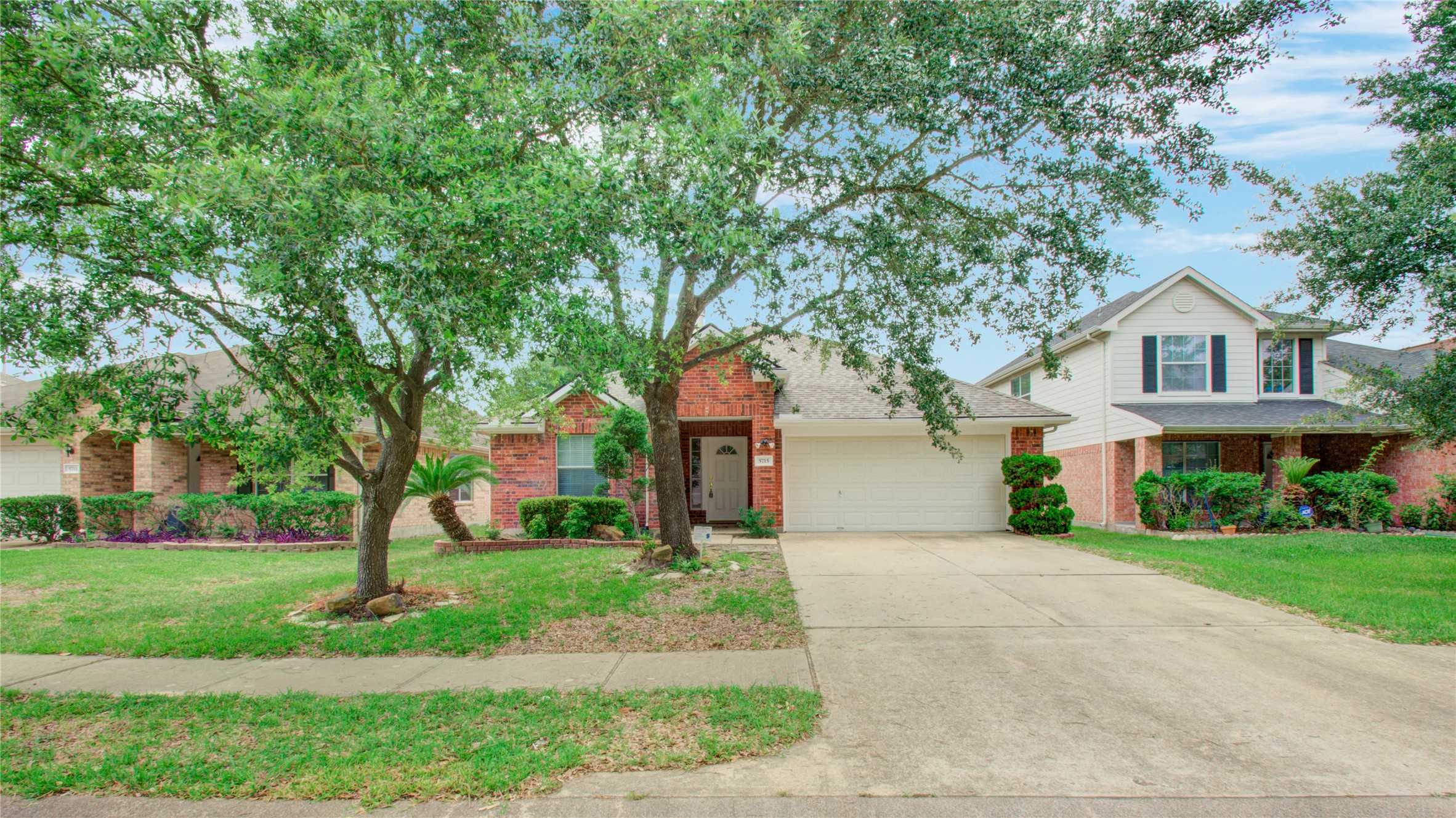 5715 Afton Ridge Lane Houston, TX 77084 - Photo 4 of 37 a front view of a house with a garden and trees