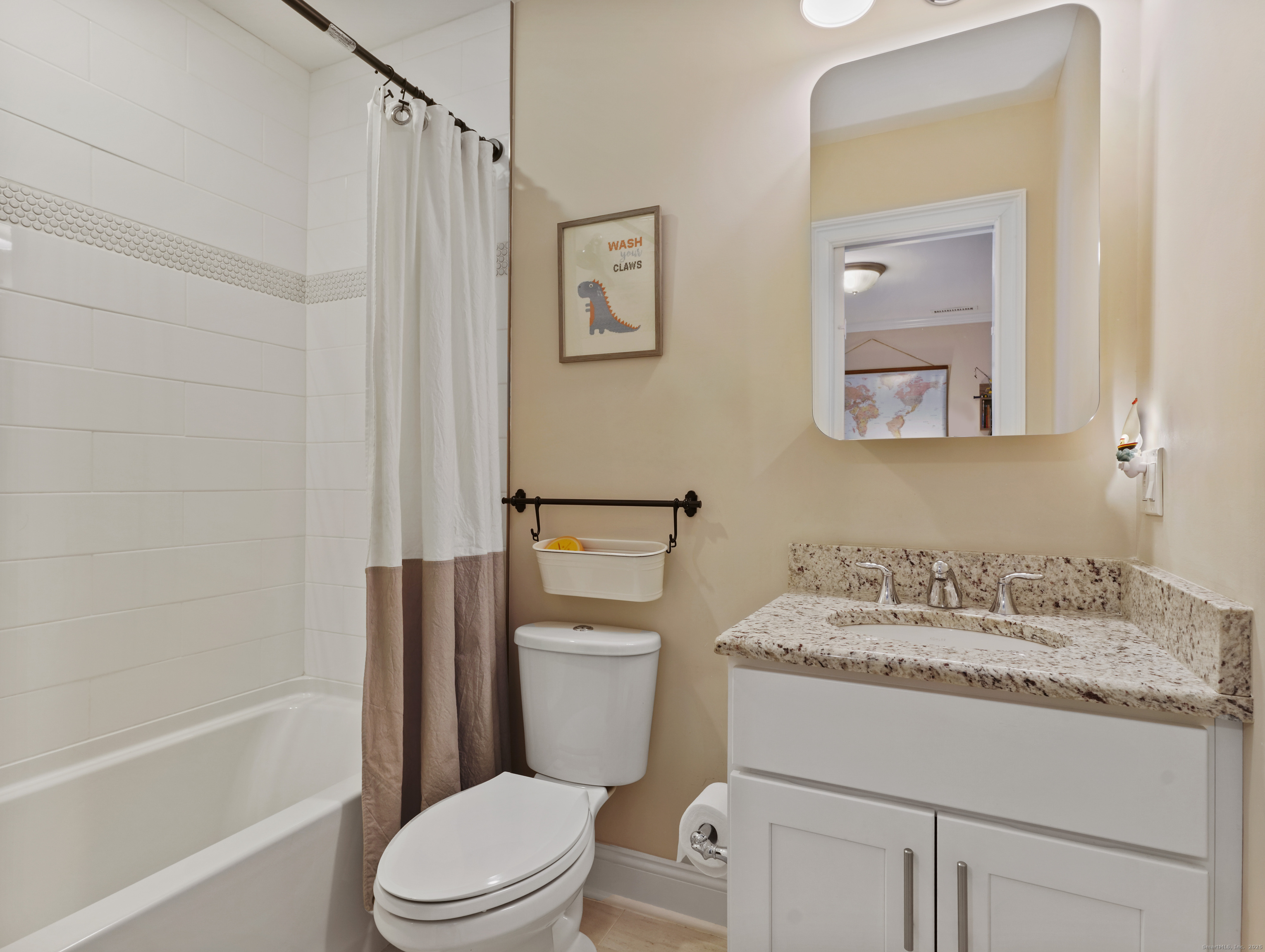 91 West Broad Street, Unit 11 Stamford, CT 06902 - Photo 16 of 26 a bathroom with a granite countertop toilet sink and mirror