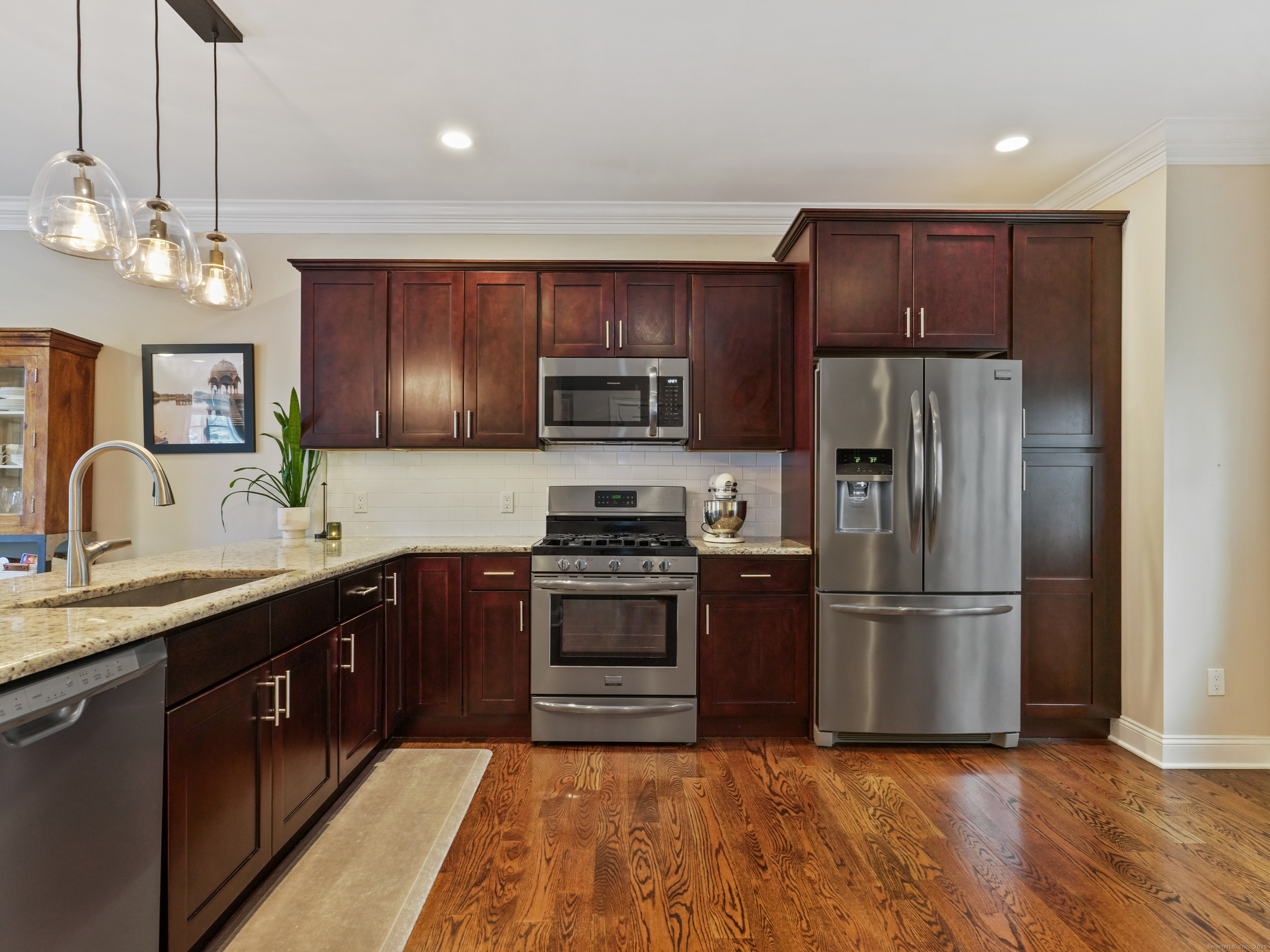91 West Broad Street, Unit 11 Stamford, CT 06902 - Photo 2 of 26 a kitchen with stainless steel appliances granite countertop a refrigerator a sink dishwasher a kitchen island with wooden cabinets and wooden floor