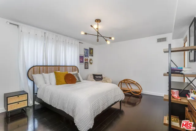 a bedroom with bed and a chandelier