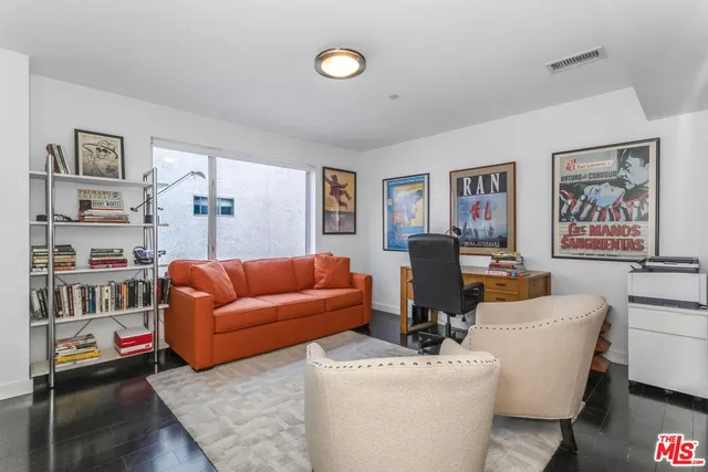 a living room with furniture a rug and a bookshelf