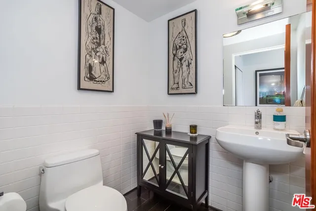 a bathroom with a toilet a sink and mirror