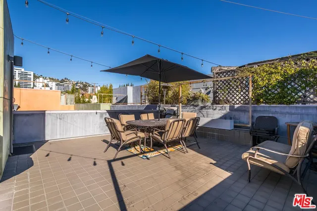 a view of a patio with table and chairs under an umbrella