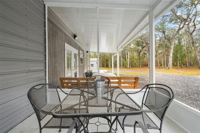 a patio with yard glass top table and chairs