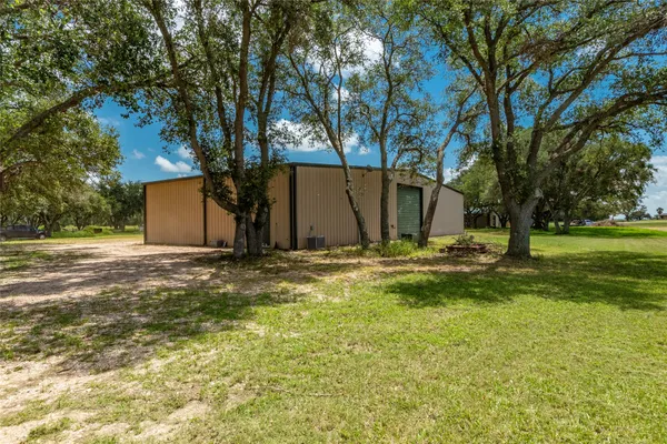 a view of a lake with a yard and large trees