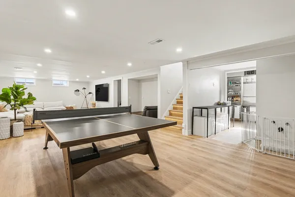 a living room with table tennis table and wooden floor