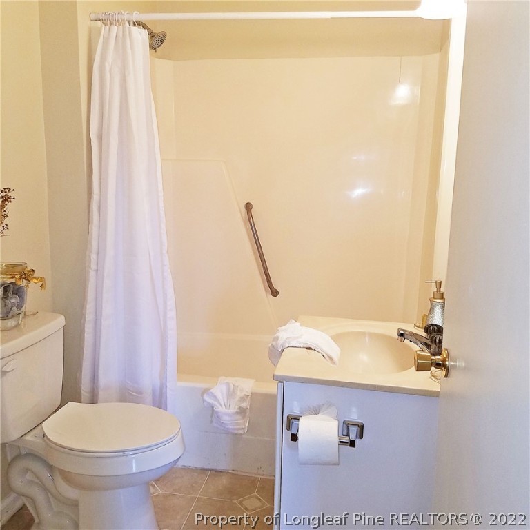 6596 Fisher Road Fayetteville, NC 28304 - Photo 15 of 27 a bathroom with a sink a toilet and shower curtain