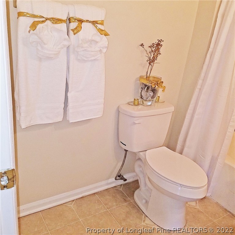 6596 Fisher Road Fayetteville, NC 28304 - Photo 16 of 27 a white toilet sitting next to a bathroom sink