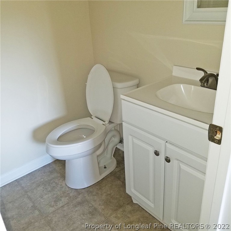 6596 Fisher Road Fayetteville, NC 28304 - Photo 21 of 27 a bathroom with a sink a toilet and a mirror